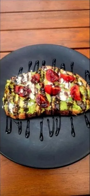 Smashed avo on sourdough with roasted cherry tomatoes, fetta and balsamic glaze